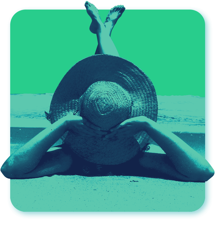 woman laying on beach sand with feet in the air